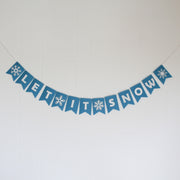 Blue 'LET IT SNOW' banner with snowflake designs on a white background